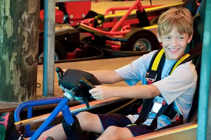 A boy driving a go kart.