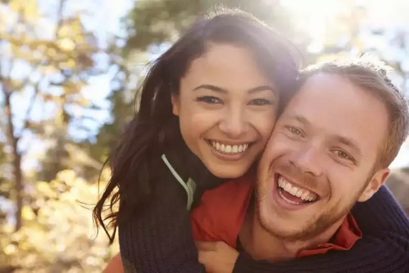 Smiling couple in the forest.